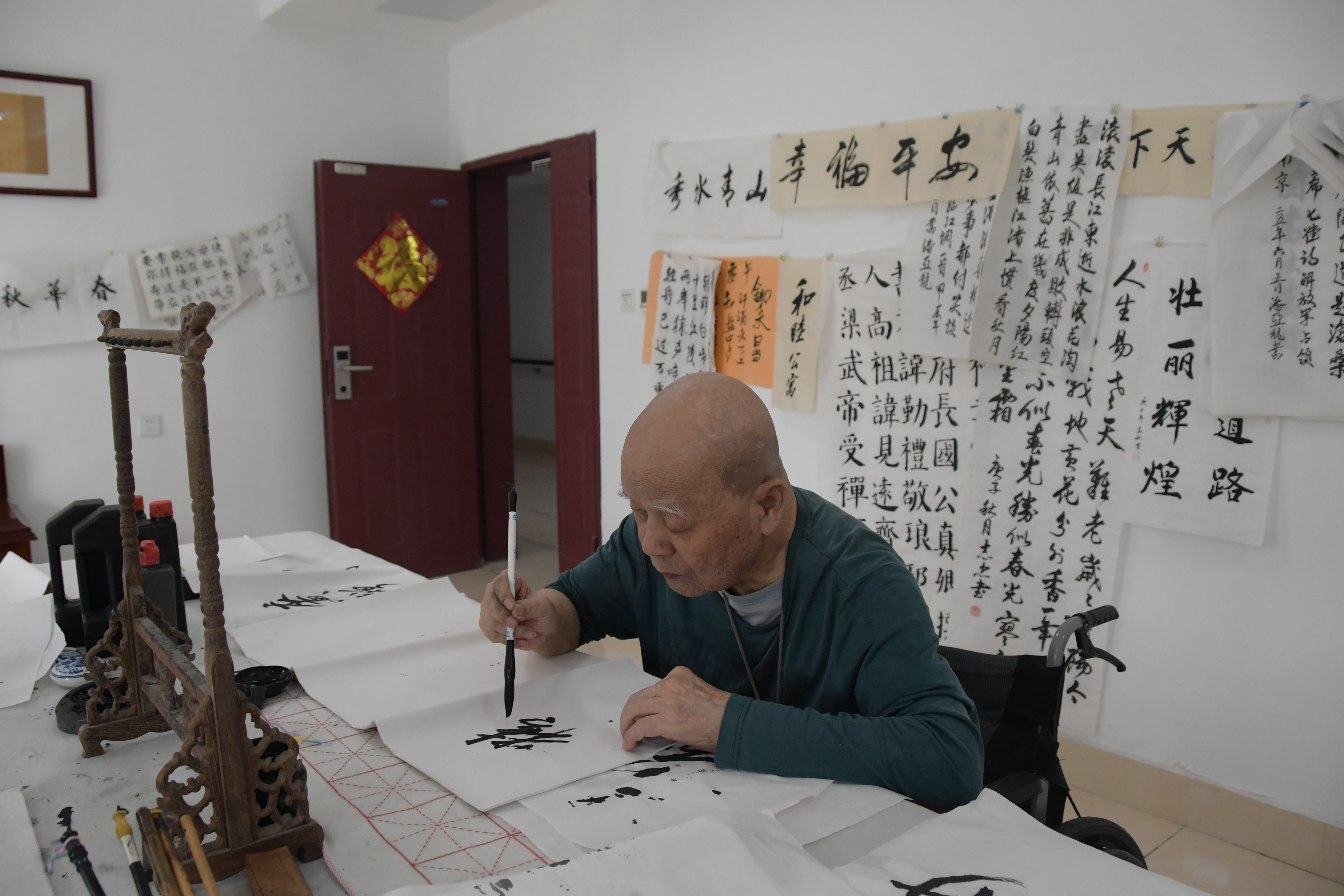长者在桌前专注练习书法