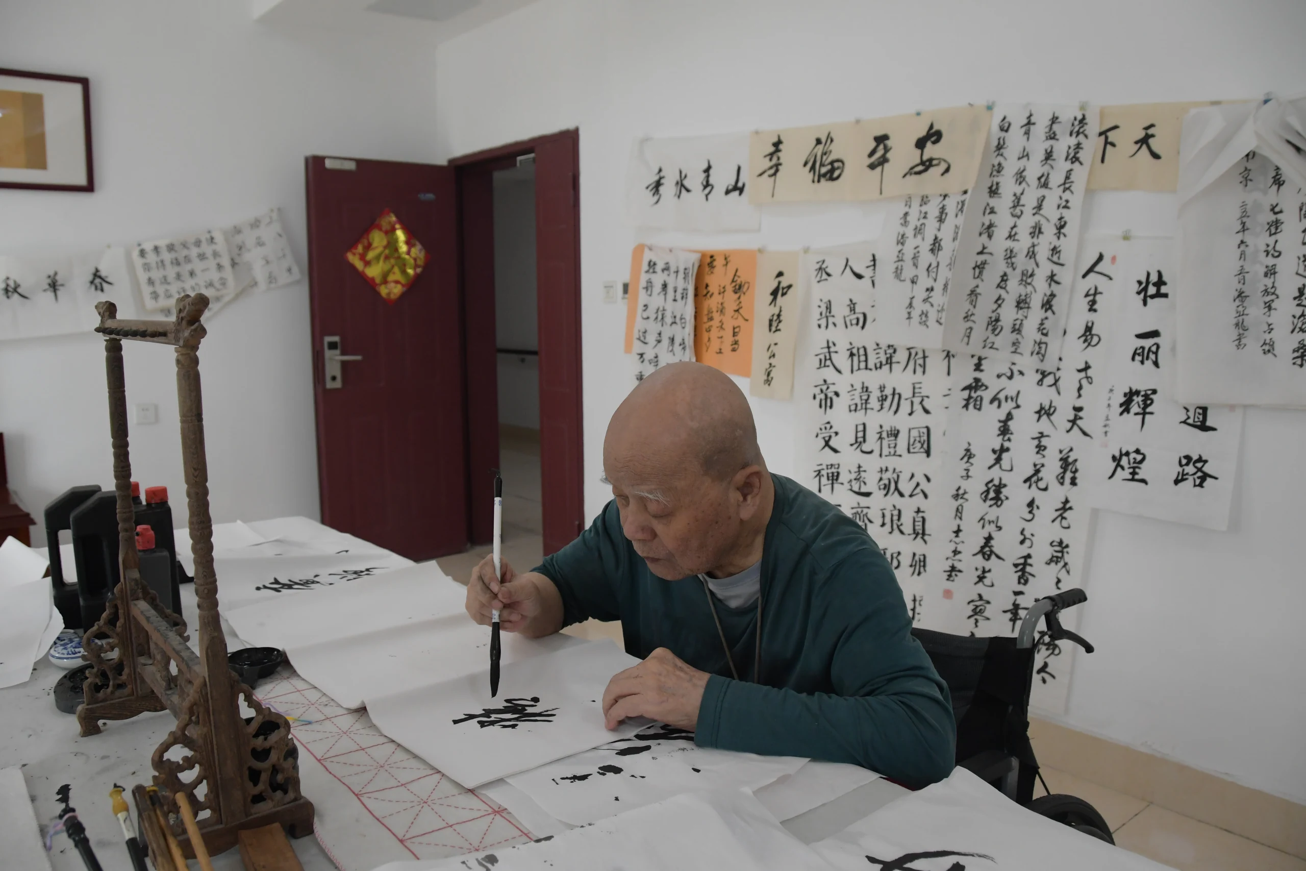 长者在桌前专注练习书法